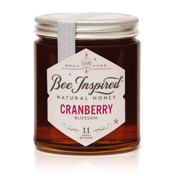 Jar of Bee Inspired Cranberry Blossom honey on a white background