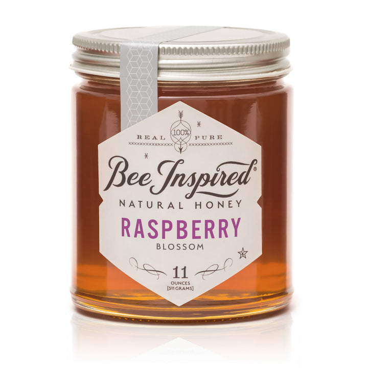 Jar of Bee Inspired Raspberry Blossom honey on a white background