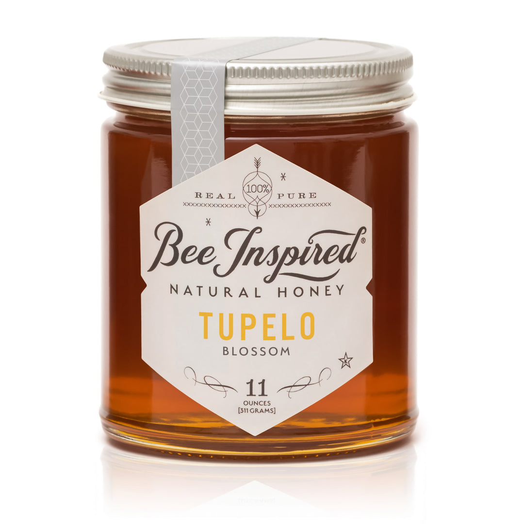 Jar of Bee Inspired Tupelo Blossom honey on a white background