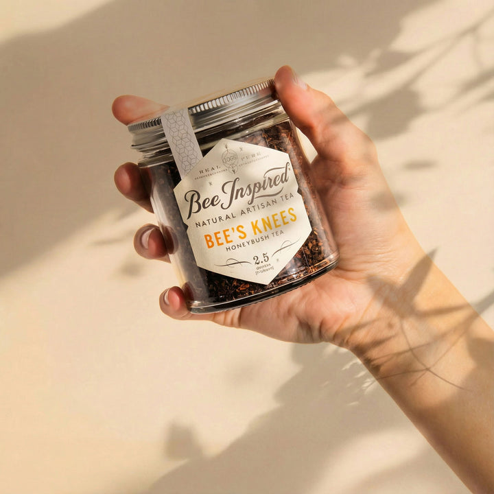 Hand holding a jar of 'Bee's Knees' honeybush tea with a 'Bee Inspired' label.