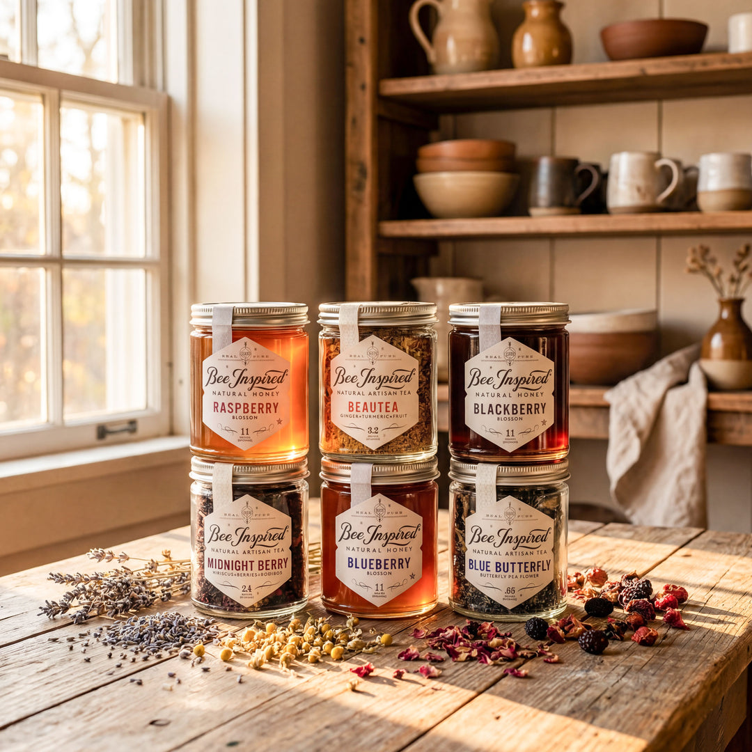 Jars of 'Bee Inspired' honey on a wooden table with a window and shelves in the background.