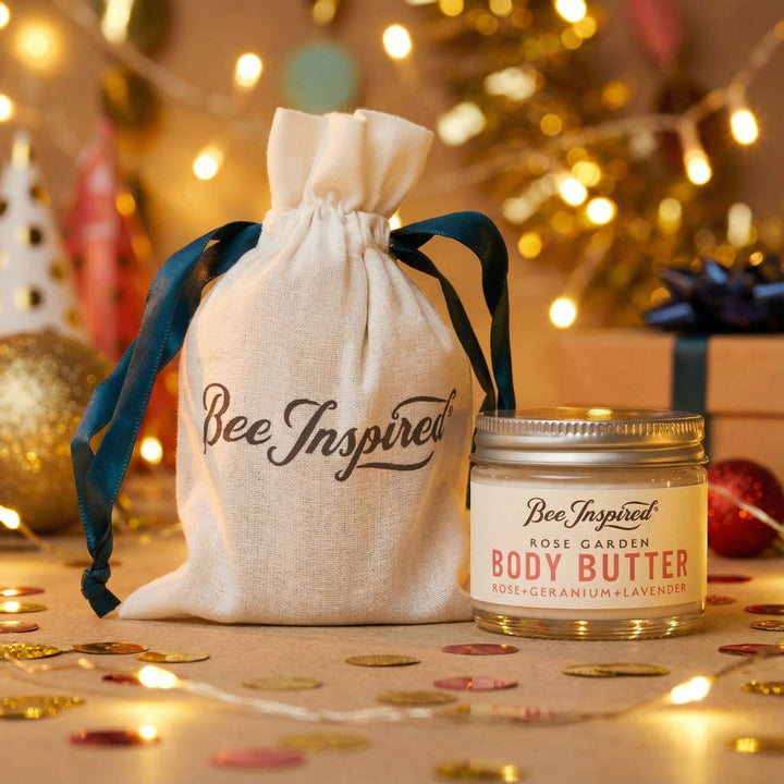 Bee Inspired body butter jar with drawstring bag on a festive background