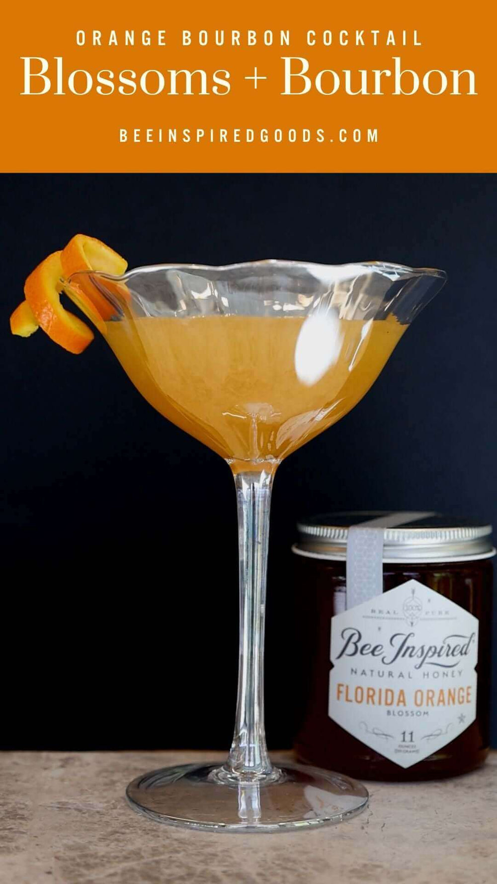 "Orange Bourbon Cocktail Blossoms+Bourbon beeinspiredgoods.com" with an orange cocktail made with Florida Orange honey