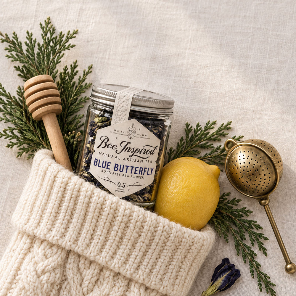 blue butterfly pea tea in holiday stocking with lemon, honey dippers and tea streiner and holiday greenery