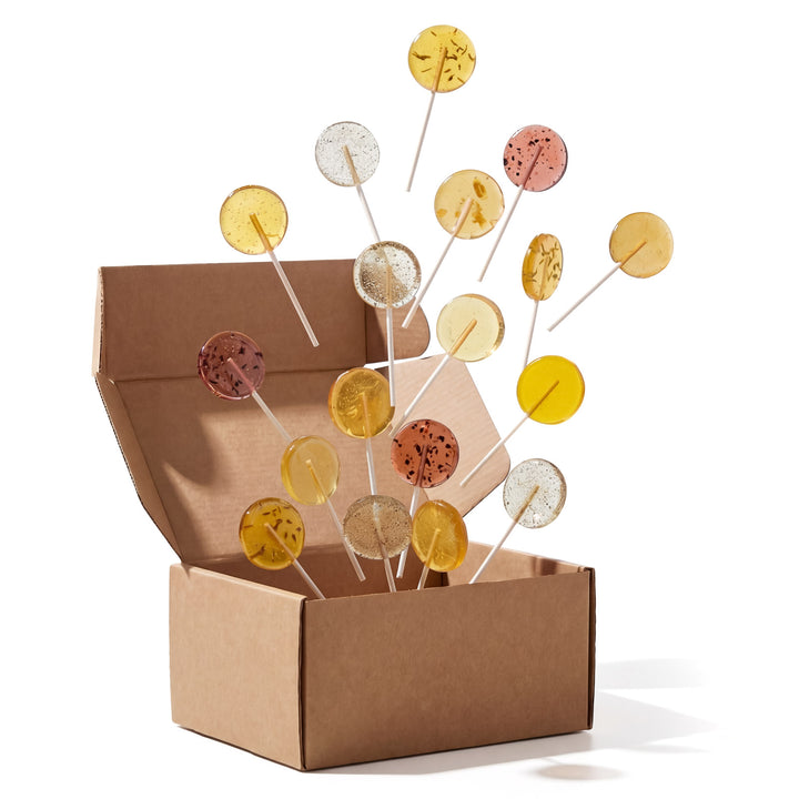lollipops on sticks in an open cardboard box against a white background
