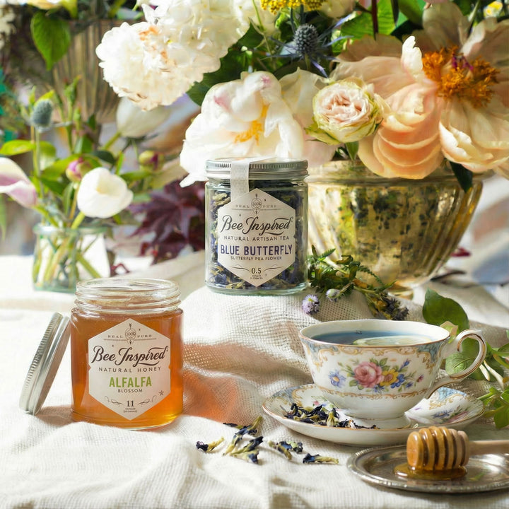 Bee Inspired honey and tea set with flowers and honeycomb on a table.

