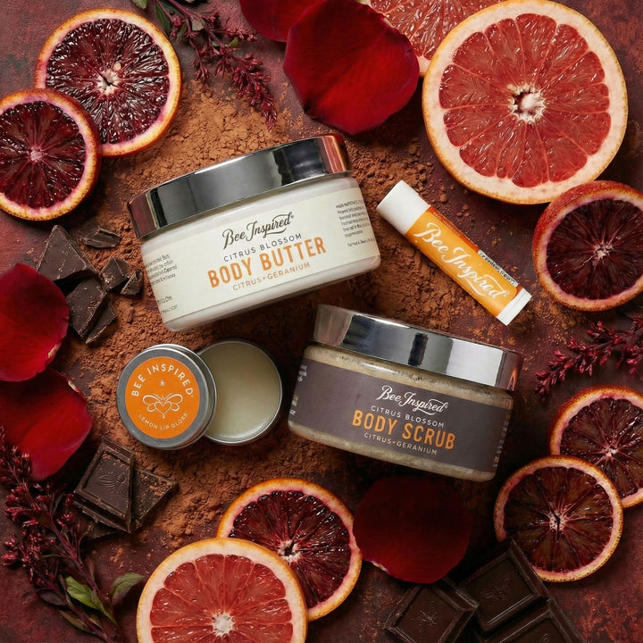 Bee Inspired body care products with blood oranges and chocolate on a dark background