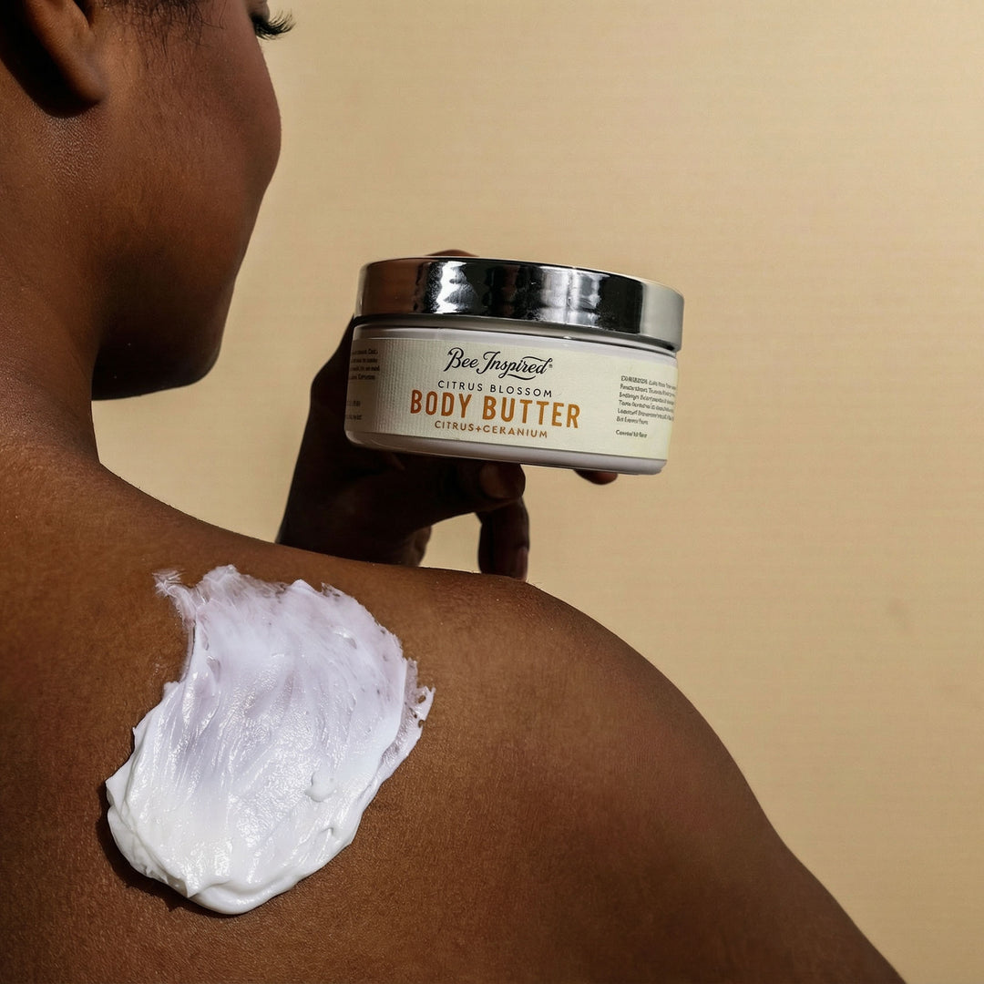 Person applying body butter to their arm with a jar of Bee Inspired Body Butter in the foreground.
