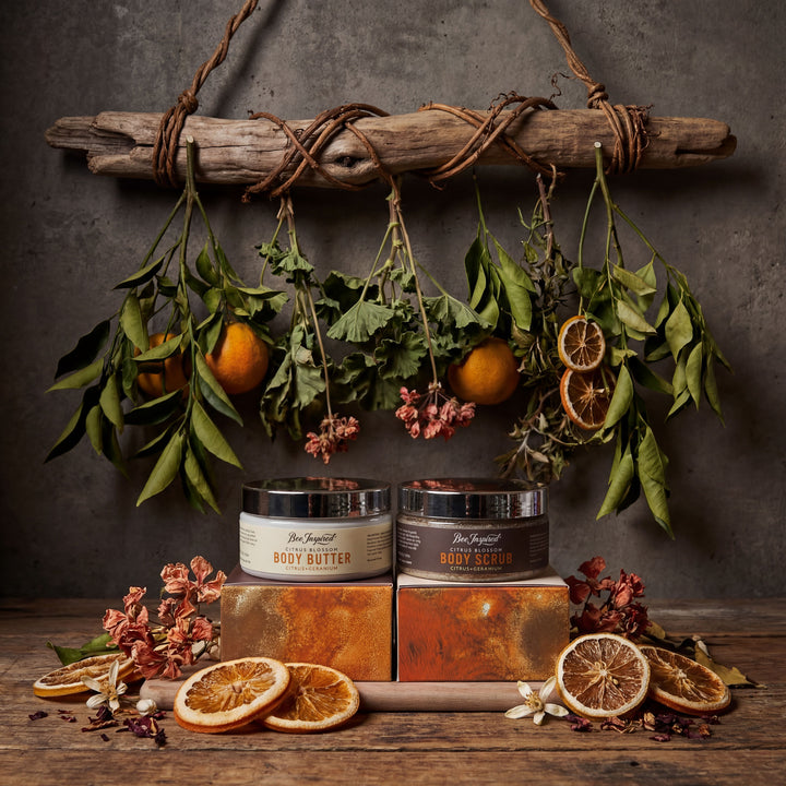 Cosmetic products on a wooden surface with decorative elements like oranges and leaves.