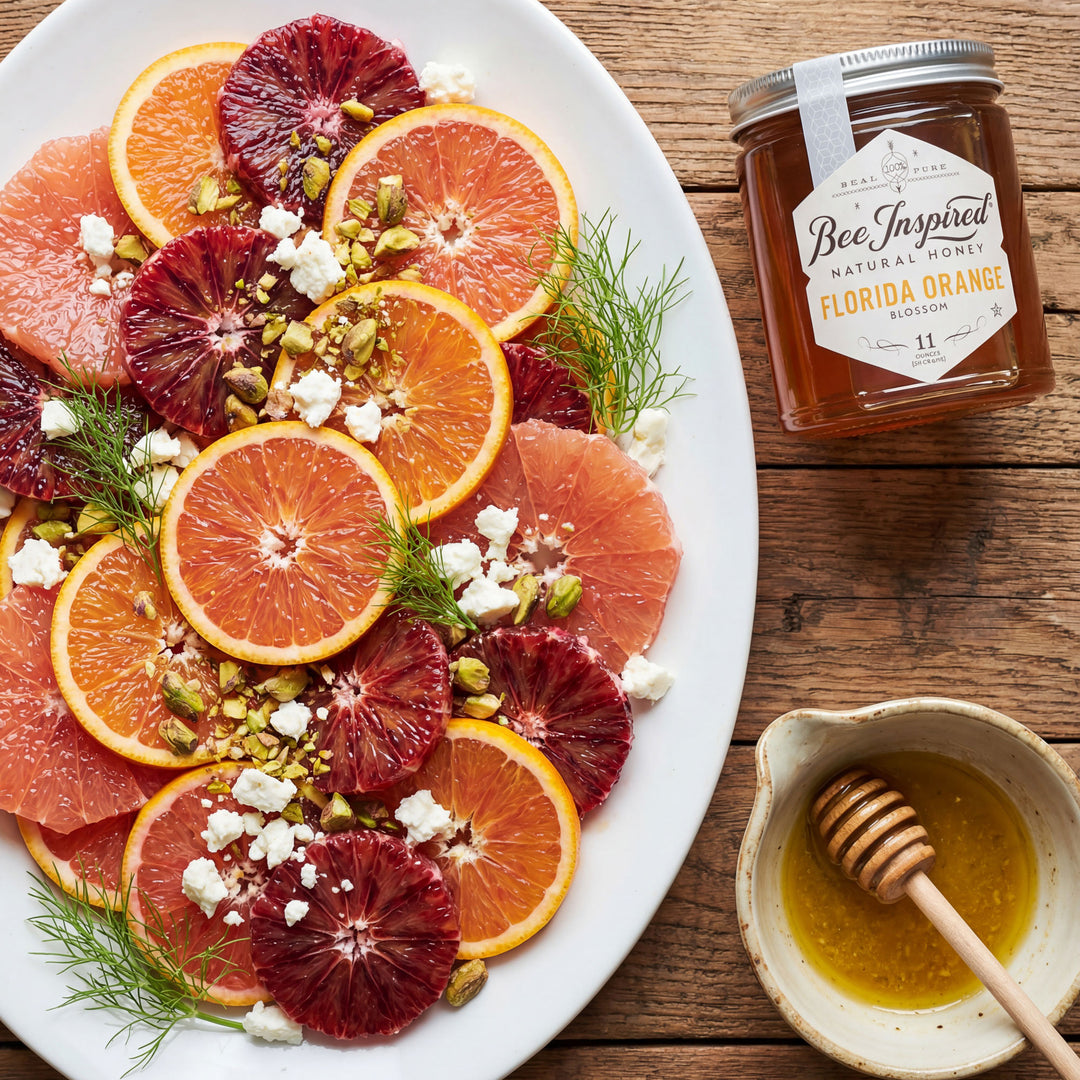 Assorted citrus fruit platter with a jar of honey on a wooden table