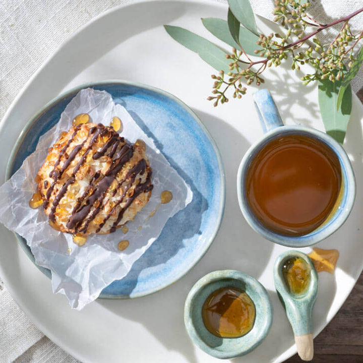 Coconut macaroons drizzled with chocolate and honey with a mug of tea 