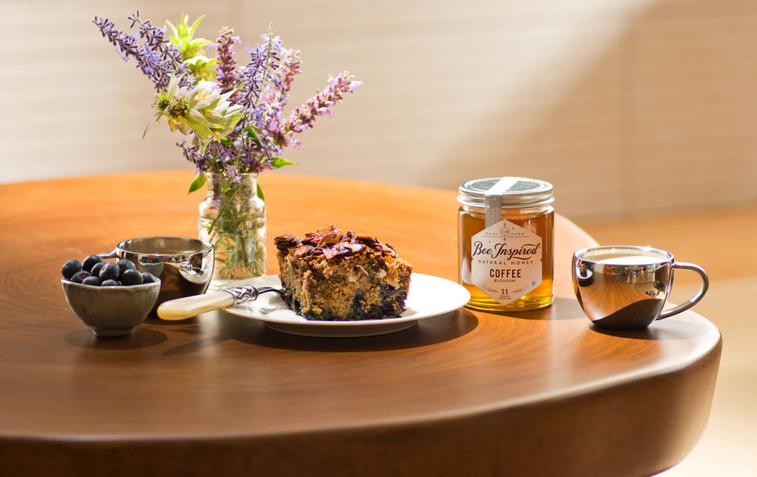 Coffee cake made with coffee honey next to blueberries and flowers