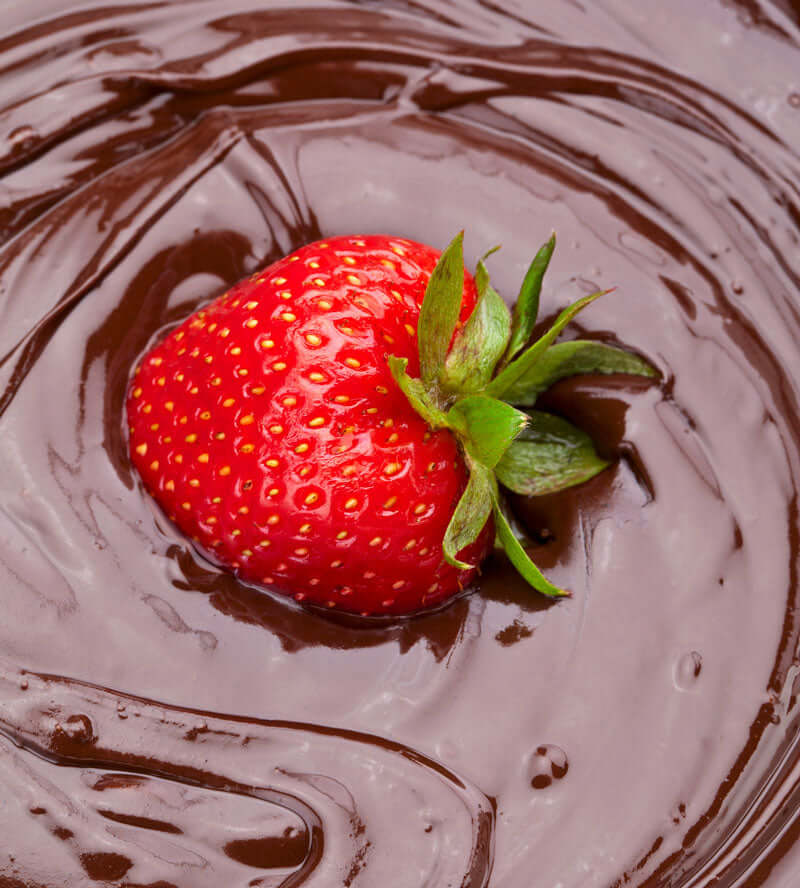 strawberry floating in melted chocolate