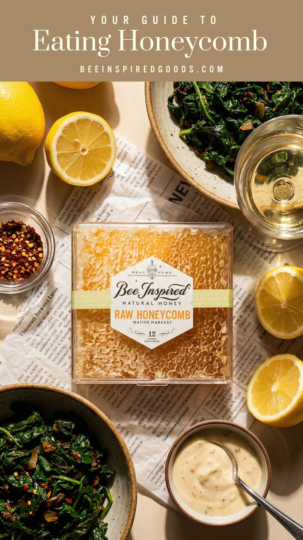 Box of Bee Inspired Raw Honeycomb with lemons, greens, and a glass of wine on a table.