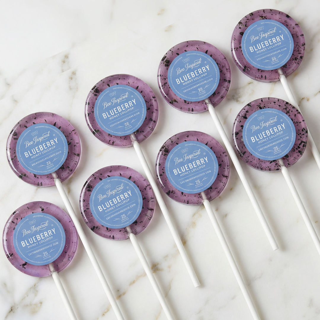 Blueberry lollipops with purple and blue labels on a marble surface