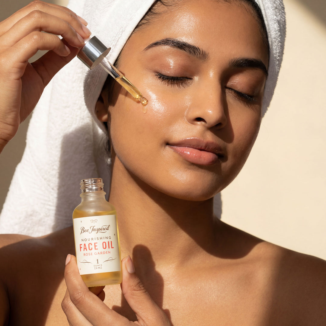 Woman applying face oil to her face with a dropper, holding a bottle of face oil.