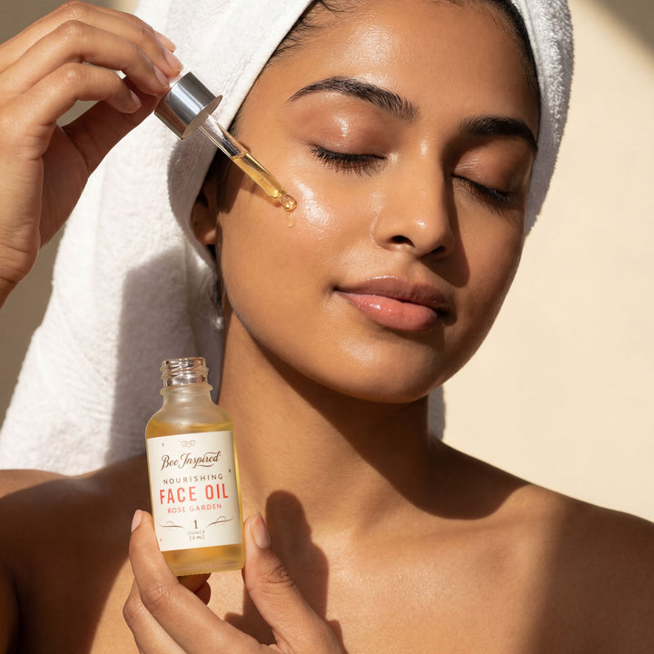 Woman applying face oil to her face with a dropper, holding a bottle of face oil.