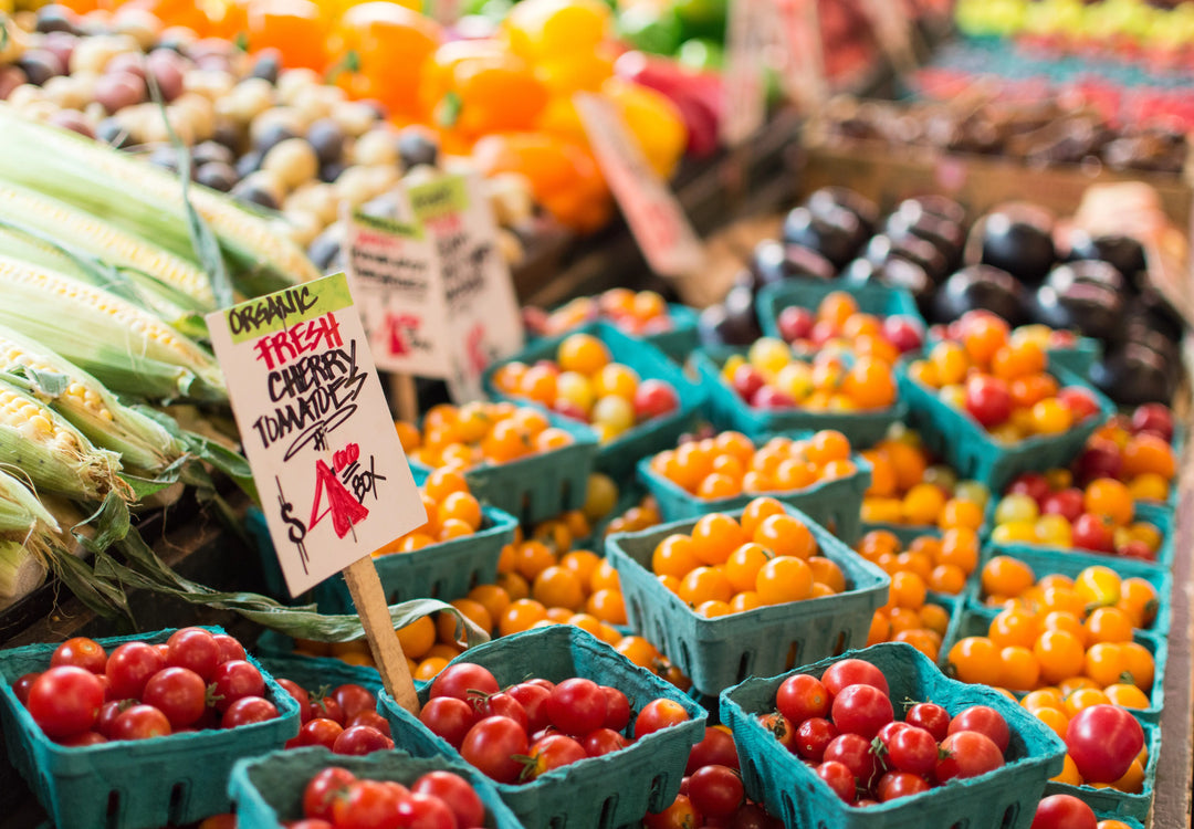 fresh orange and red cherry tomatoes at a farmers market