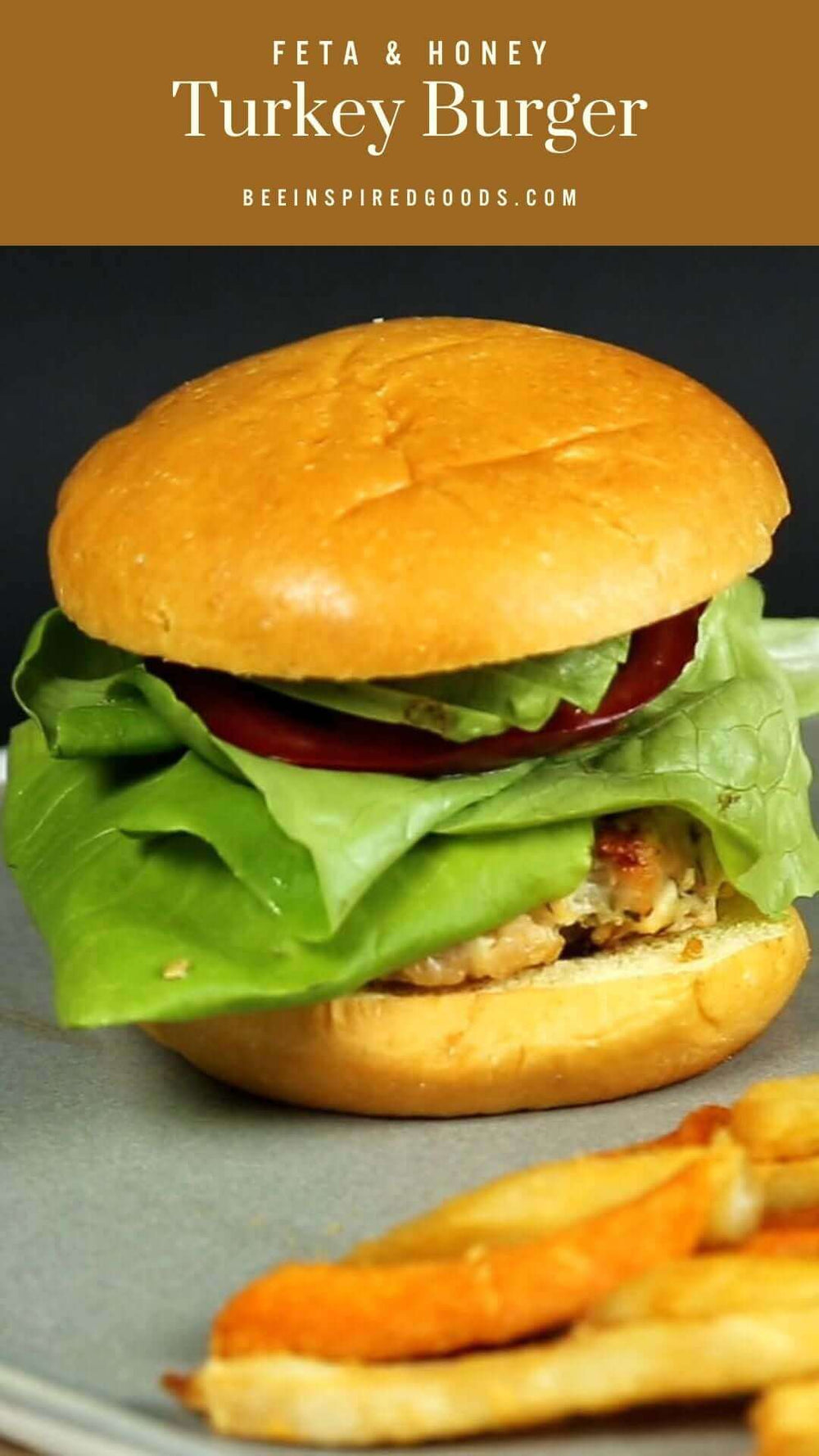 "Feta & Honey Turkey Burger beeinspiredgoods.com" with a turkey burger with lettuce, tomato, and avocado, with a side of fries