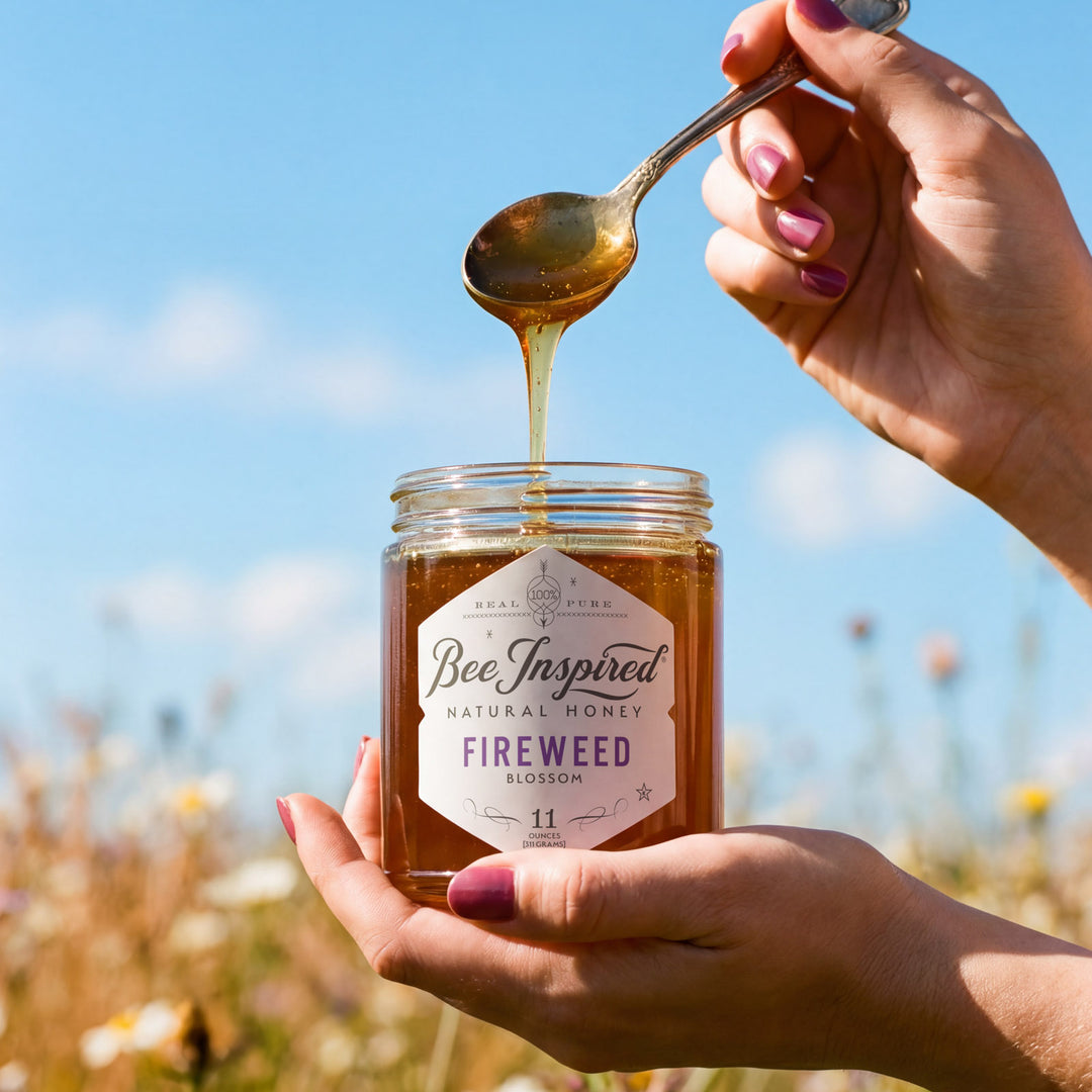 fireweed honey open by hands spoon showing the honey inside jar