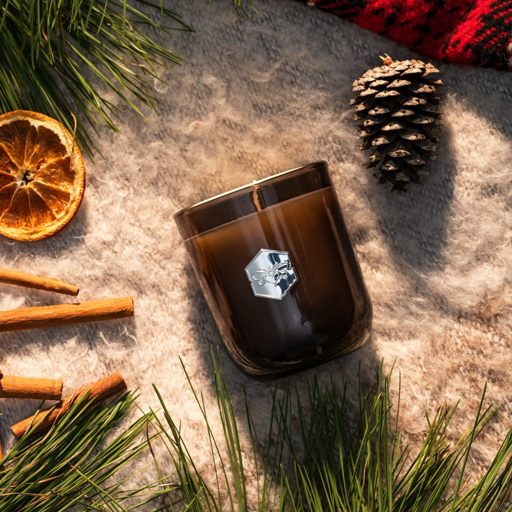 luxe candle surrounded by holiday trim