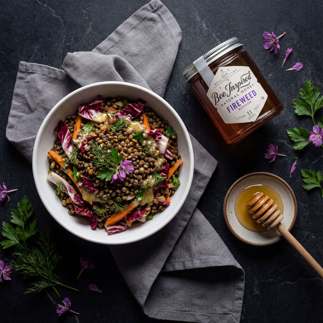 french lentil salad in white bowl on black table with bee inspired fireweed honey