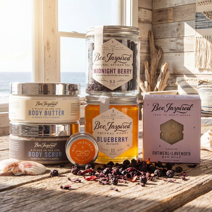 Bee Inspired natural products including honey, body scrub, and soap on a wooden surface with a window view.