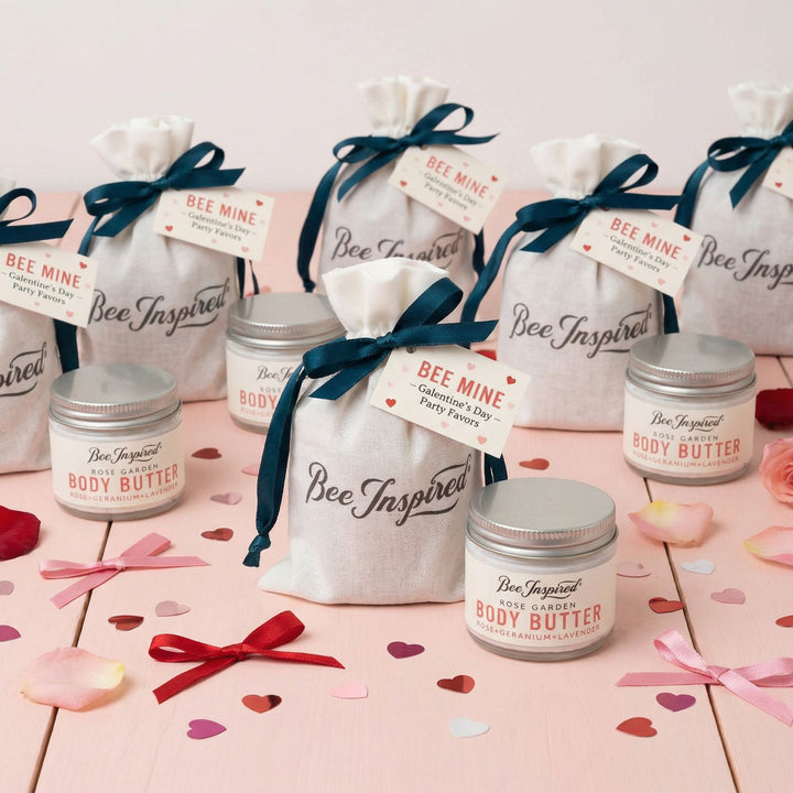 Bee Inspired body butter party favor jars and bags on a pink surface with decorative ribbons and heart shapes.