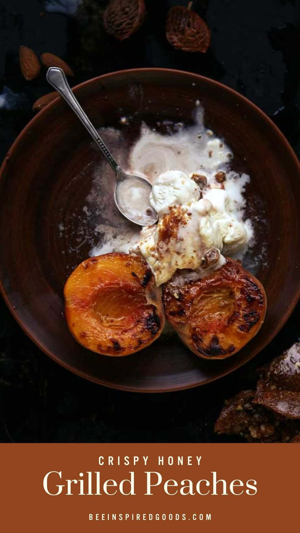 two halves of a grilled peach sits in a bowl with white cream and a spoon "Crispy Honey Grilled Peaches beeinspiredgoods.com""