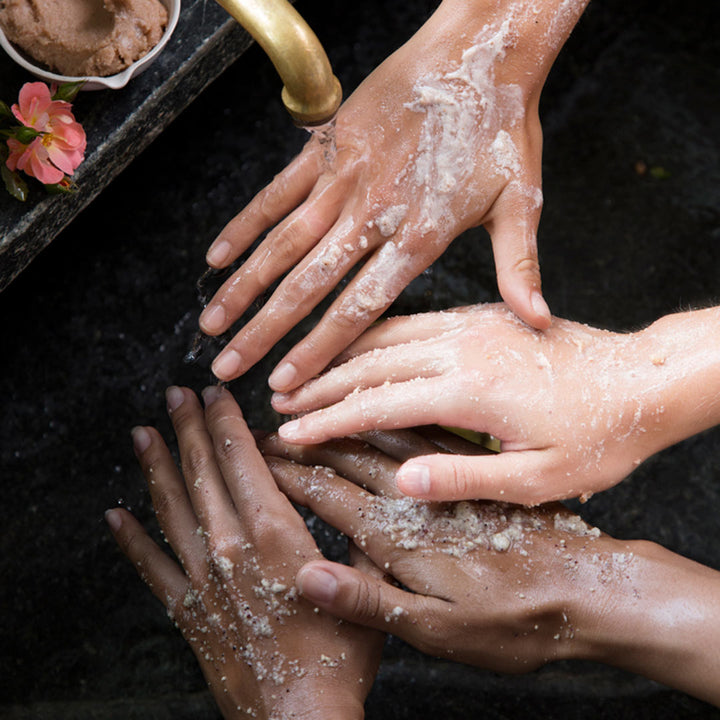 hands covered with scrub in a running sink