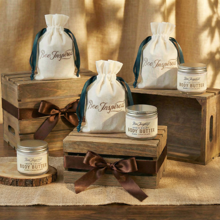 Bee Inspired body butter jars with drawstring bags on wooden crates and surfaces.