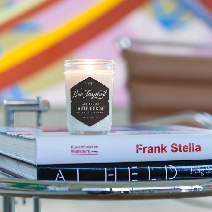 Haute Cocoa Soy Jelly Jar Candle on books with art in background