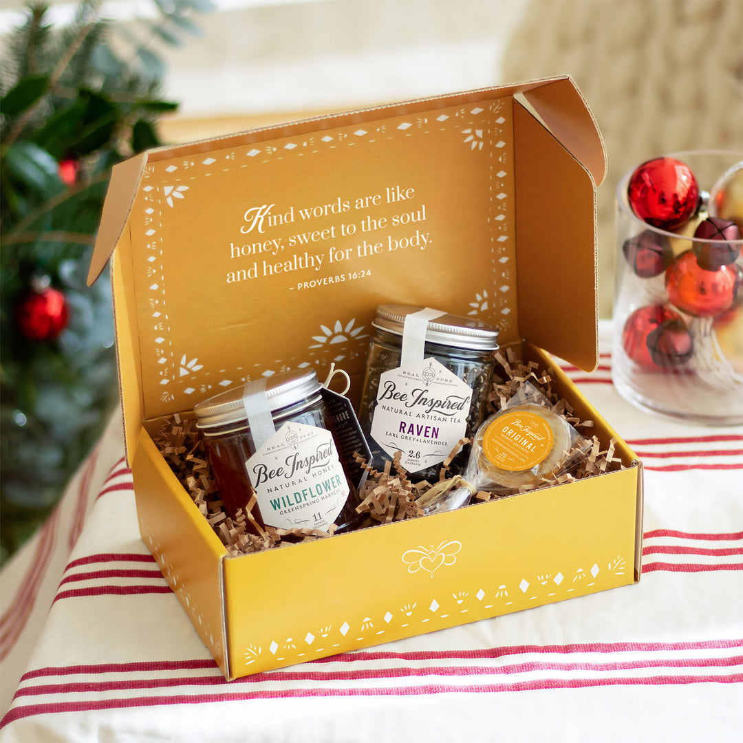 Hey Honey gift set displaying Raven tea, Wildflower honey, and honey lollipop from Bee Inspired Honey House in Owings Mills in front of holiday decorations 