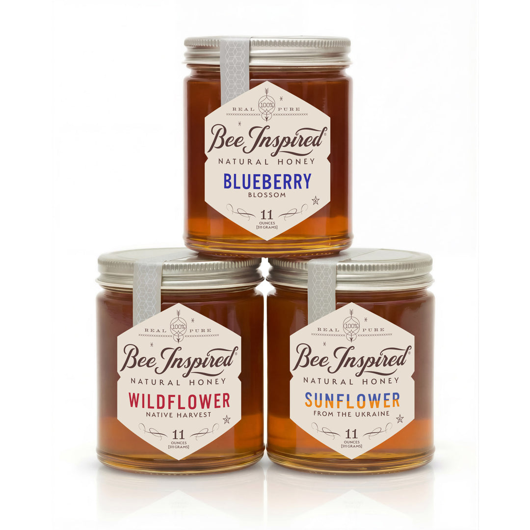 Three jars of 'Bee Inspired' honey stacked on a white background
