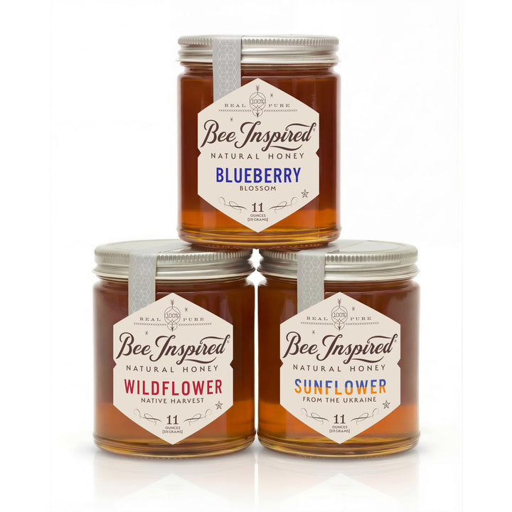 Three jars of 'Bee Inspired' honey stacked on a white background
