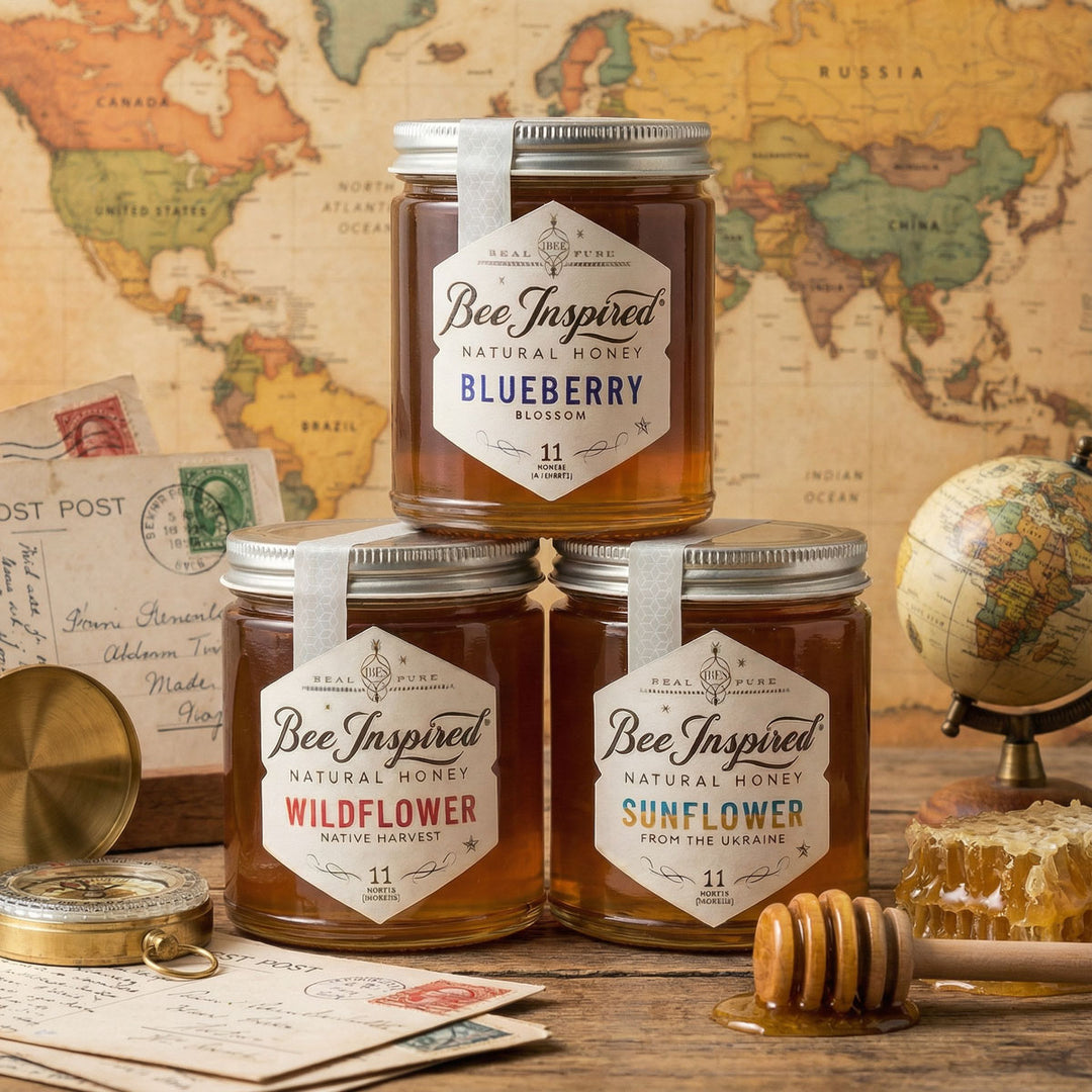 Jars of 'Bee Inspired' honey with labels on a wooden surface and world map background