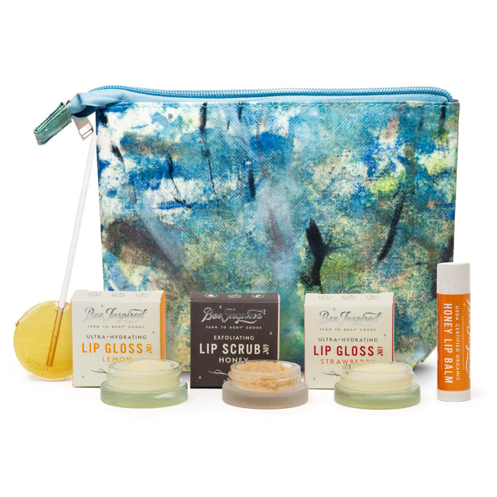 Set of lip care products including lip glosses and scrub with a decorative pouch on a white background.