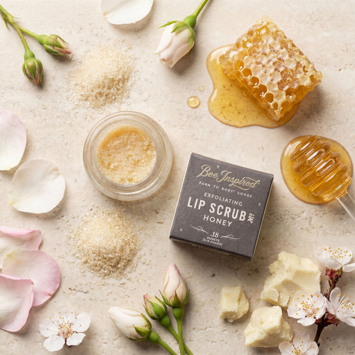 Lip scrub with honey and flowers on a light surface
