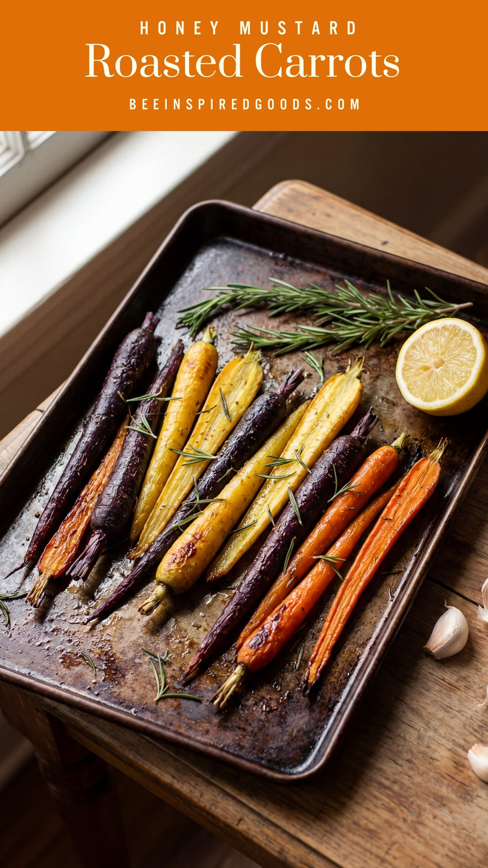 Roasted carrots on a baking tray with lemon and rosemary, set against a wooden surface.