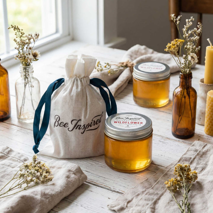 Jars of honey with 'Bee Inspired' label on a wooden surface with decorative elements.