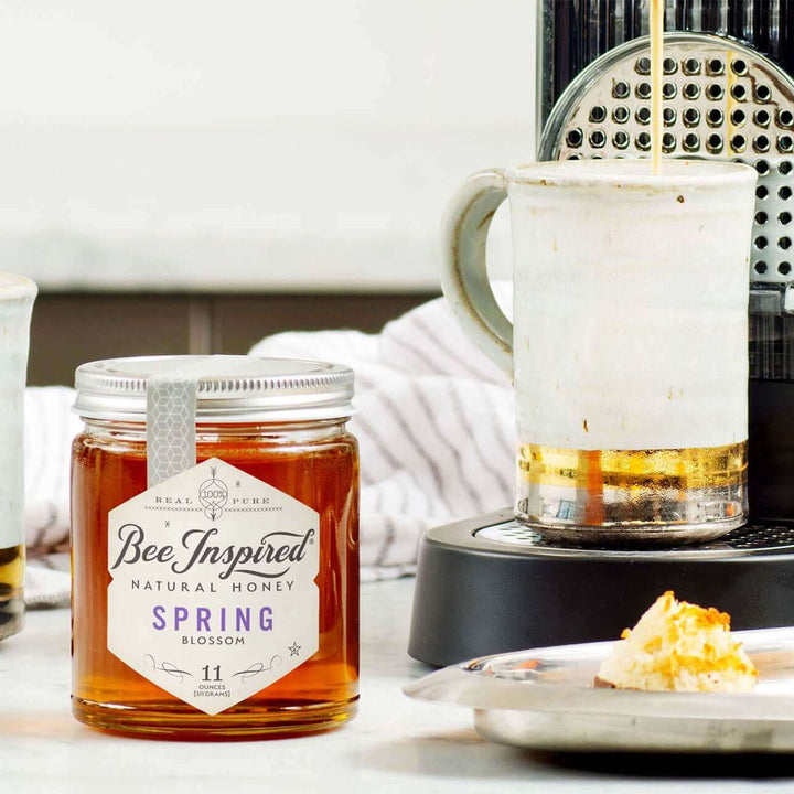 a coffee maker, a jar of spring honey, and a plate of macaroons
