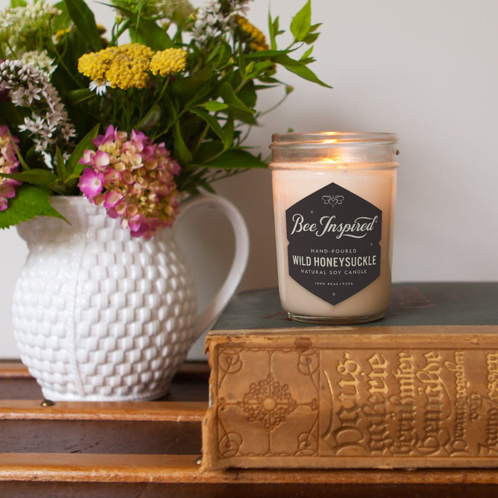 wild honeysuckle soy candle on book with flowers