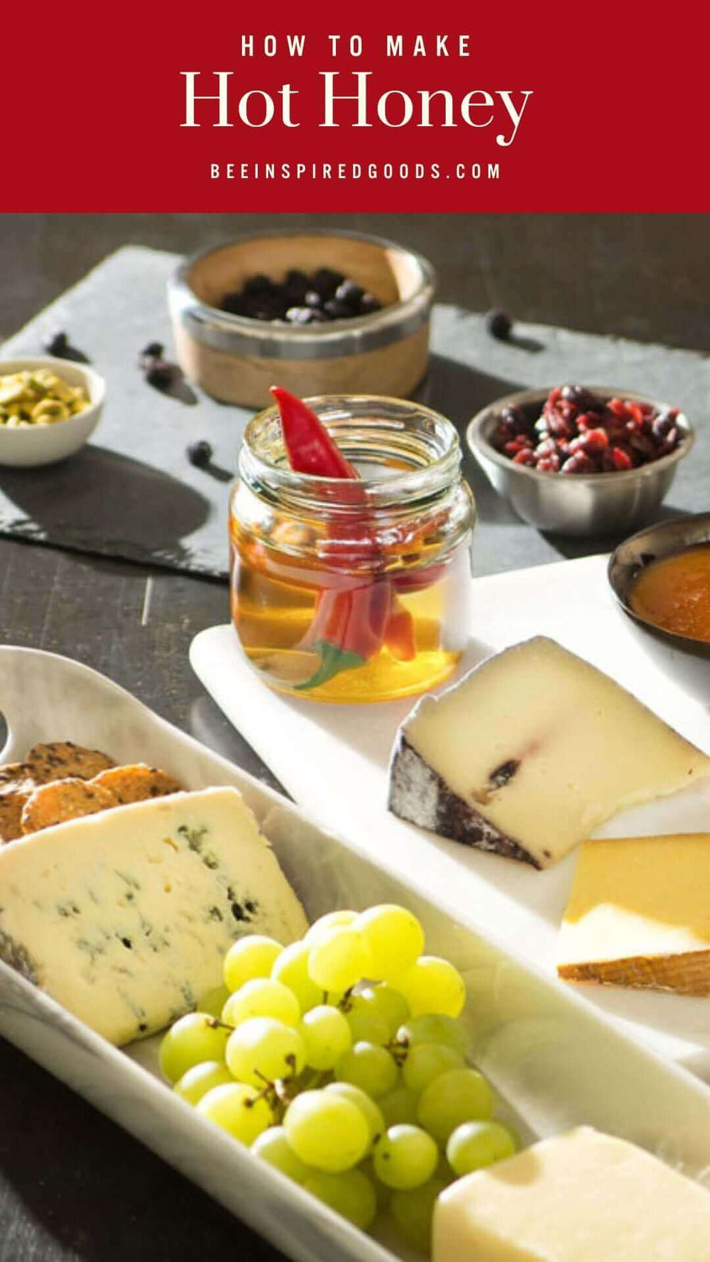 "How to Make Hot Honey beeinspiredgoods.com" with a pepper-infused jar of honey on a charcuterie board
