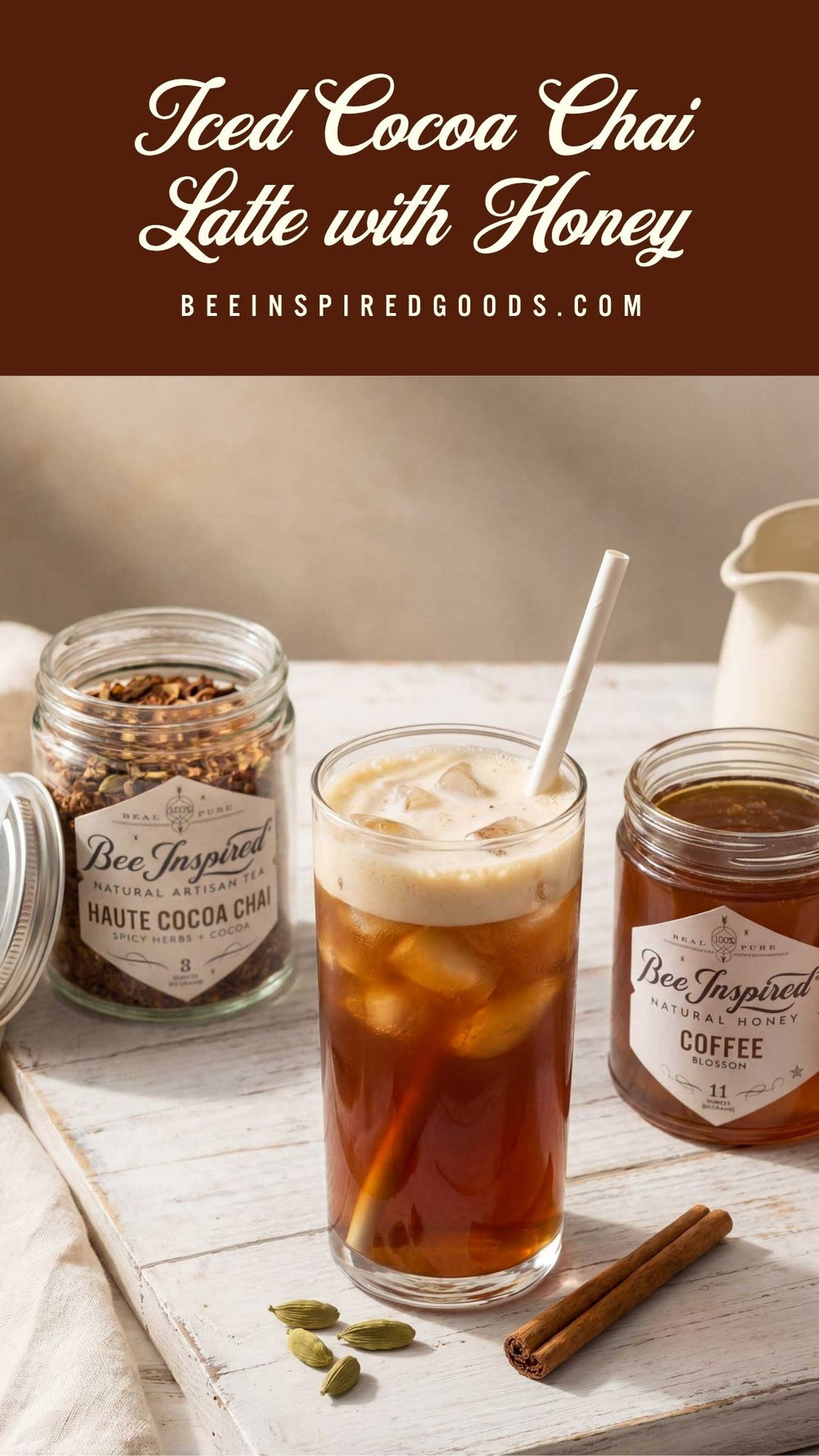 Iced cocoa chai latte with honey on a wooden surface, featuring jars of ingredients and a spoon.