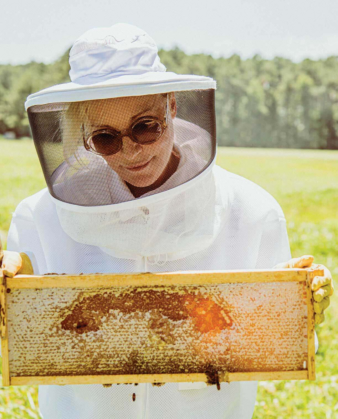 beekeeper Kara holding a hive frame