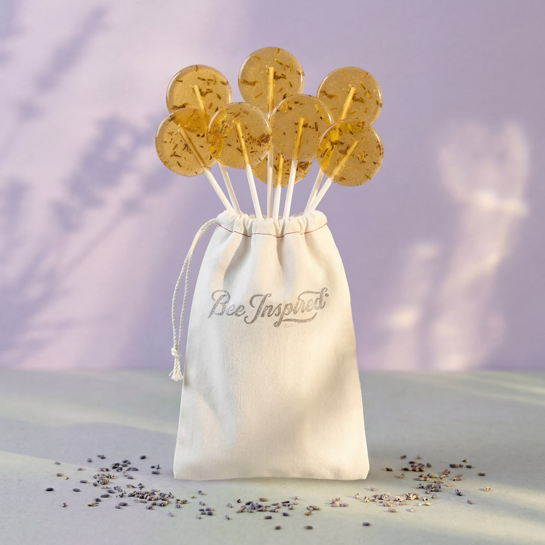 Bowl of lollipops with a 'Bee Inspired' drawstring bag on a light background