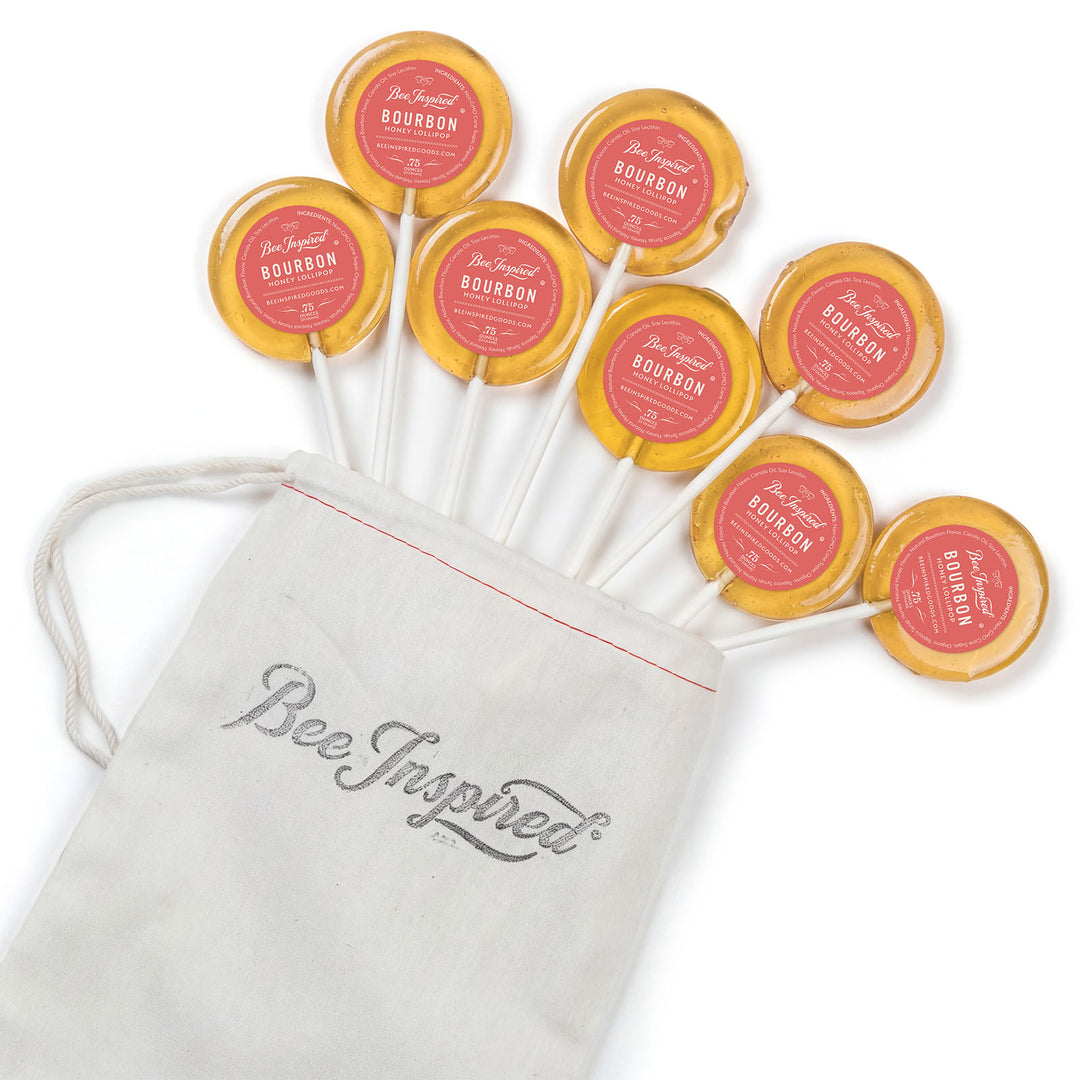 Bourbon lollipops with a 'Bee Inspired' drawstring bag on a white background