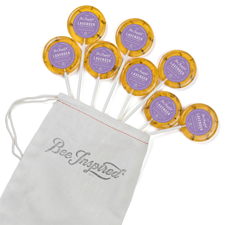 Bee-themed lollipops with 'Bee Inspired' drawstring bag on a white background