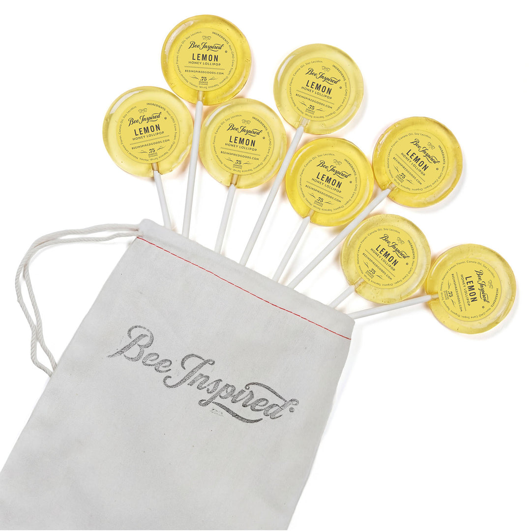 Yellow lemon-themed lollipops with a 'Bee Inspired' drawstring bag on a white background