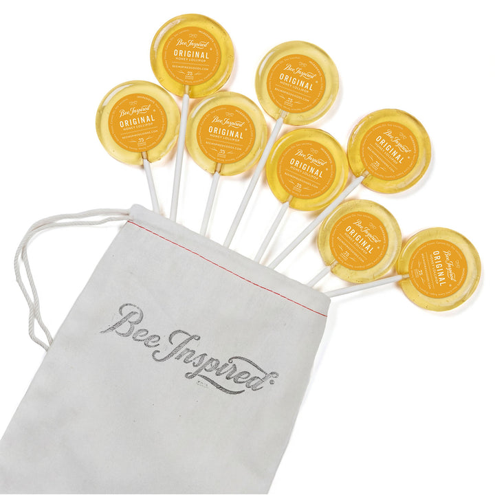 Yellow lollipops with 'Bee Inspired' packaging on a white background